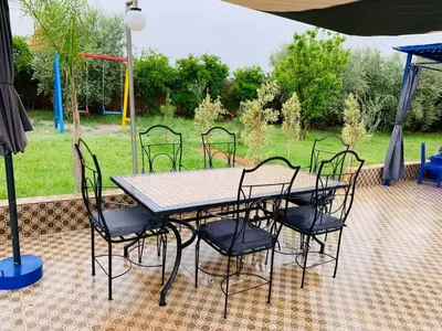 a table and chairs sitting under an umbrella at Villa yanii siin in Marrakech