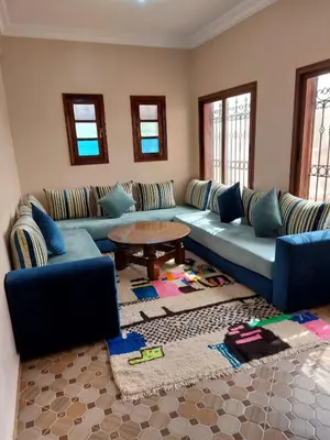 a living room with a blue couch and a table at Villa yanii siin in Marrakech