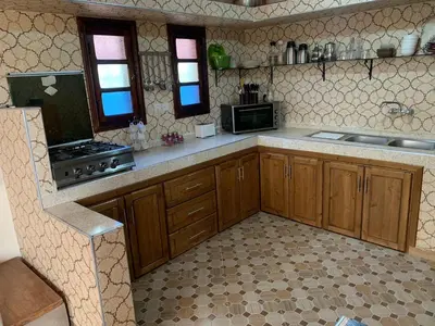 a kitchen with wooden cabinets and a stove top oven at Villa yanii siin in Marrakech