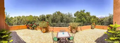 a patio with a table and potted plants on a balcony at Villa Atlas Secret in Ourika