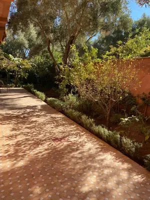 a brick path with trees and bushes on the side at Villa Atlas Secret in Ourika
