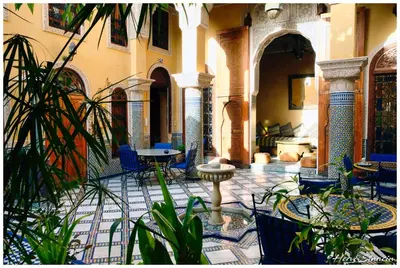 a courtyard with tables and chairs and plants at Riad Layalina Fes in Fès