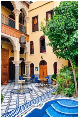 a courtyard with a fountain and a building at Riad Layalina Fes in Fès