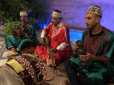 a group of three men sitting next to a baby at Riad Layalina Fes in Fès