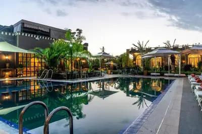 a swimming pool with tables and chairs next to a building at The Lemonary Marrakech in Marrakech