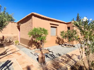 a house with a tree in front of it at Maison d'hôtes Tigminou - Adults Only in Aït Ben Haddou