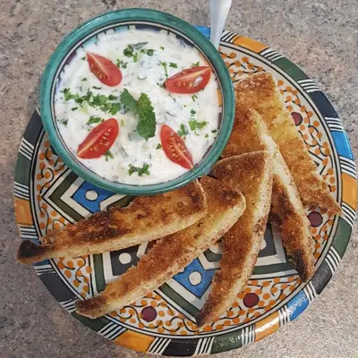 a plate of food with a bowl of dip and some toast at Maison d'hôtes Tigminou - Adults Only in Aït Ben Haddou