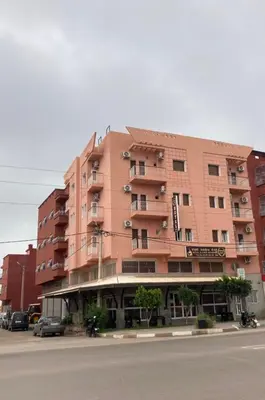 a large pink building on the side of a street at Hotel Achokre in Oulad Yaïch