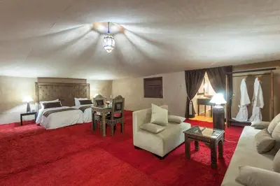 a large bedroom with a bed and a couch at LEMNAOUAR ERG CAMP in Merzouga