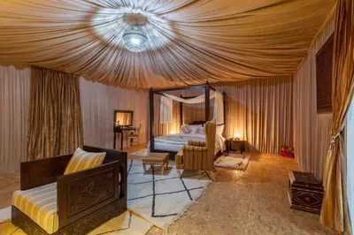 a hotel room with a bed and a couch at LEMNAOUAR ERG CAMP in Merzouga