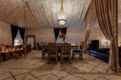 a living room with a table and a couch at LEMNAOUAR ERG CAMP in Merzouga
