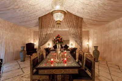 a dining room with a table and a chandelier at LEMNAOUAR ERG CAMP in Merzouga
