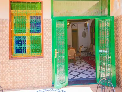 a green door with a window on a house at Riad Mahrez in Fès