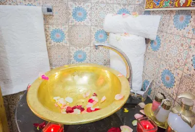 a bathroom with a gold bowl with candy in it at Riad Mahrez in Fès