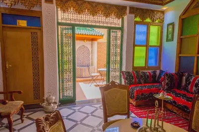 a living room with a couch and some windows at Riad Mahrez in Fès