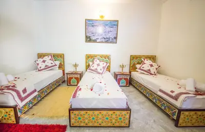 a room with three beds in a room at Riad Mahrez in Fès