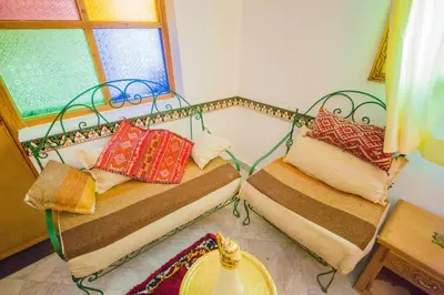 two beds sitting in a room with a window at Riad Mahrez in Fès