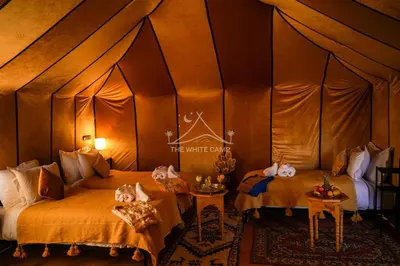 a room with two beds in a tent at The White Camp Merzouga - Official Luxury Desert Camp & Camel Tours in Merzouga