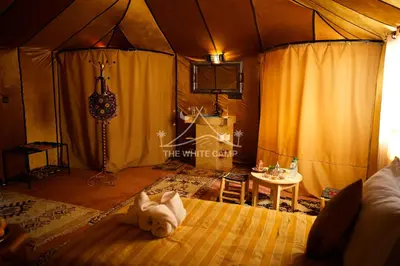 a bedroom with a bed with a teddy bear on it at The White Camp Merzouga - Official Luxury Desert Camp & Camel Tours in Merzouga