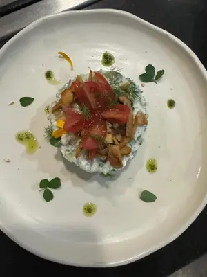 a white plate with a dish of food on it at Bakkal Farm Agrolodge in Marrakech