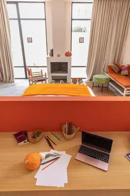 a desk with a laptop computer on top of a room at Bakkal Farm Agrolodge in Marrakech