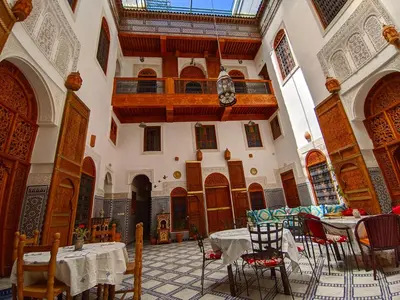 a room with tables and chairs in a building at Riad Fès Center in Fès