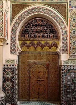 a large wooden door in a building with tiles at Riad Fès Center in Fès