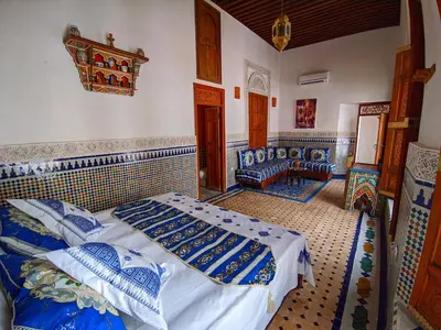 a bedroom with two beds and a couch in it at Riad Fès Center in Fès