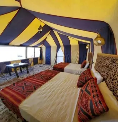 a bedroom with two beds and a tent at Merzouga Nice luxury Camp in Merzouga