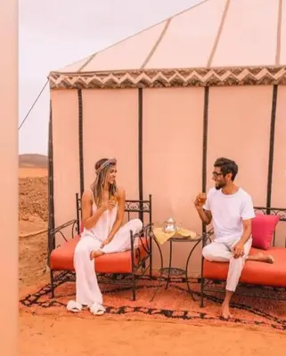 a man and a woman sitting under a tent at Merzouga Nice luxury Camp in Merzouga