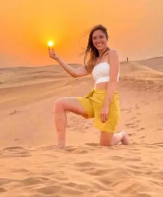 a woman on the beach with a light in her hand at Merzouga Nice luxury Camp in Merzouga