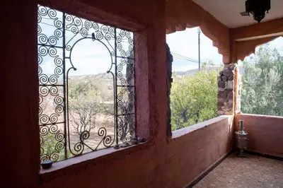 a window in a house with a view of the mountains at Afoulki Ecotourism Guest House in Telouet