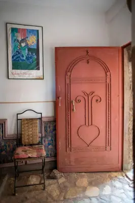 a red door with a heart on it in a room at Afoulki Ecotourism Guest House in Telouet