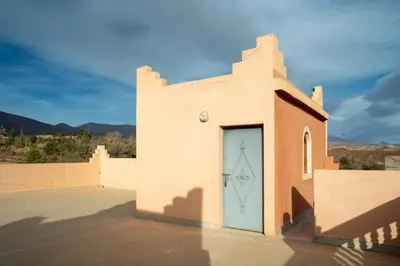 a building with a blue door on the side of it at Afoulki Ecotourism Guest House in Telouet