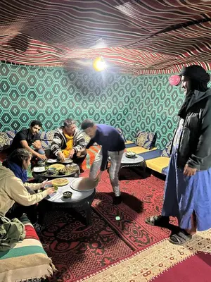 a group of people sitting around a table in a room at Mhamid Sahara Camp - Mhamid El Ghizlane in Mhamid