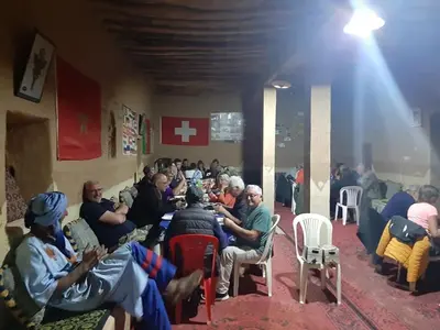 a group of people sitting in chairs in a room at Auberge Dinosaur Kem Kem in Tafraoute Sidi Ali