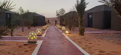a row of lights in the middle of a desert at Merzouga Camel Trekking Camp in Merzouga