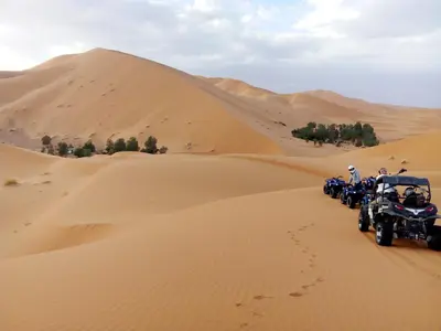 a group of people riding motorcycles in the desert at Merzouga Ana luxury Camp in Merzouga