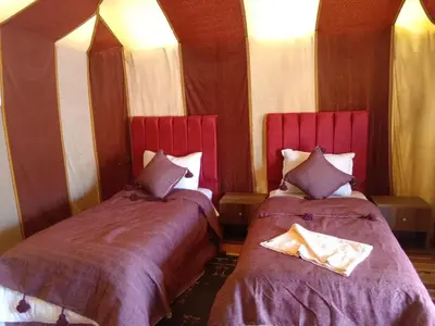 two beds sitting next to each other in a room at Merzouga Ana luxury Camp in Merzouga