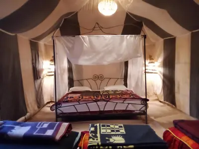 a bedroom with a canopy bed in a room at Merzouga Ana luxury Camp in Merzouga