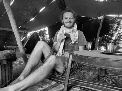 a man sitting at a table wearing a scarf at Merzouga Ana luxury Camp in Merzouga