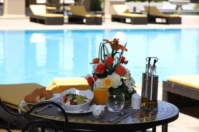 a tray of food on a table in front of a pool at Z Hotel Meknes in Meknès