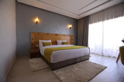 a bedroom with a bed and a large window at Z Hotel Meknes in Meknès