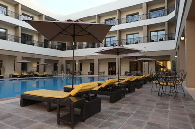 a hotel pool with lounge chairs and umbrellas at Z Hotel Meknes in Meknès