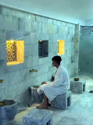 a man sitting on a bench in a bathroom at Eventi Club by cité des sports adarissa in Fès
