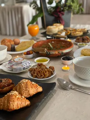 a table topped with plates of food on a table at Eventi Club by cité des sports adarissa in Fès