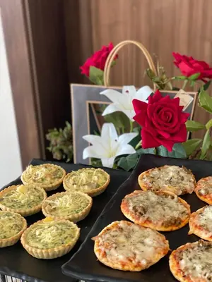 a tray of small pizzas on a table with flowers at Eventi Club by cité des sports adarissa in Fès