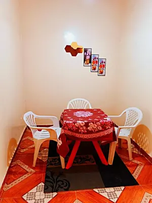 a dining room table with four chairs and a red table and chairsktop at Merzouga apartments holiday in Merzouga