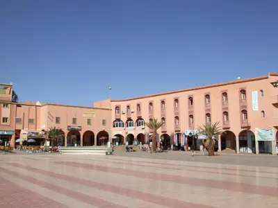 a town square with a large pink building at Hotel Bab Sahara in Ouarzazate