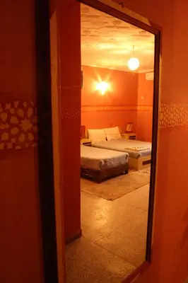 a view of a bedroom with a bed through a mirror at Hotel Bab Sahara in Ouarzazate